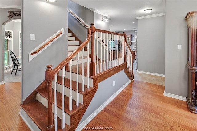 stairs featuring hardwood / wood-style flooring and ornamental molding