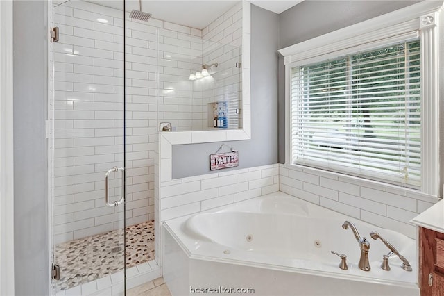 bathroom featuring tile patterned flooring, shower with separate bathtub, and vanity