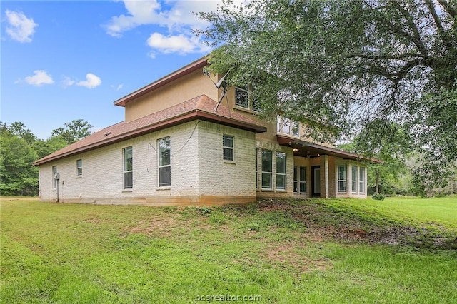 back of house with a lawn