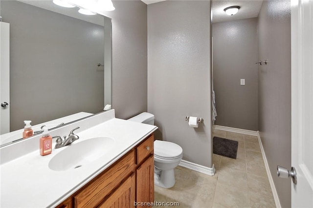 bathroom featuring tile patterned flooring, vanity, and toilet