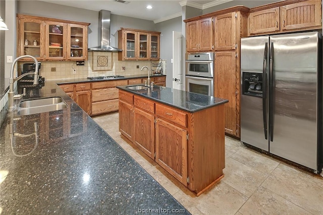 kitchen with stainless steel appliances, a kitchen island with sink, wall chimney exhaust hood, and sink