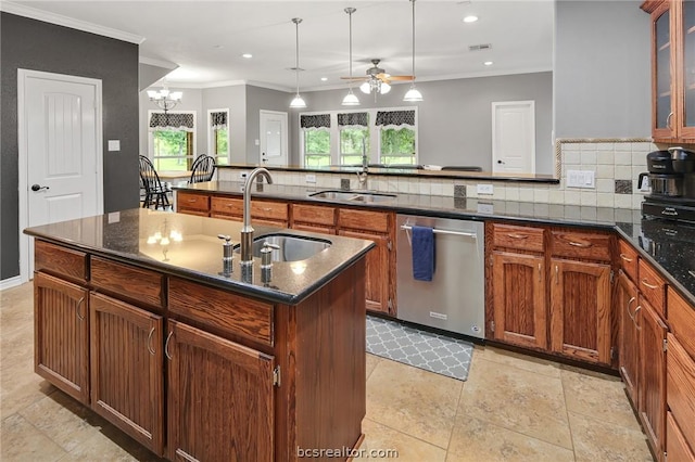 kitchen featuring dishwasher, tasteful backsplash, a kitchen island with sink, and sink