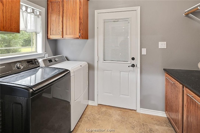 laundry area with cabinets and washer and clothes dryer