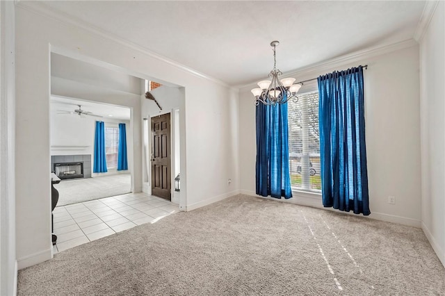 carpeted empty room featuring ceiling fan with notable chandelier, a fireplace, and ornamental molding