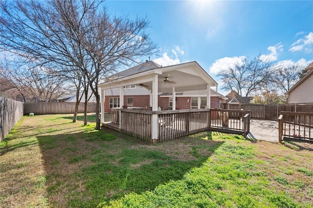 view of yard with a wooden deck and ceiling fan