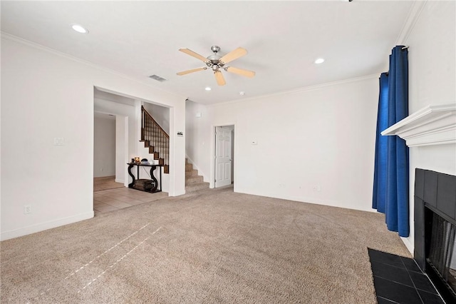 unfurnished living room with a tile fireplace, carpet floors, ceiling fan, and crown molding