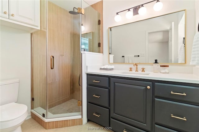 bathroom featuring tile patterned floors, vanity, toilet, and walk in shower