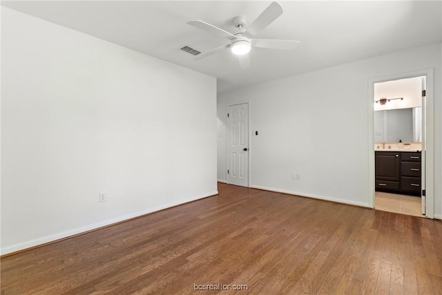 unfurnished bedroom with ensuite bath, ceiling fan, and light hardwood / wood-style flooring