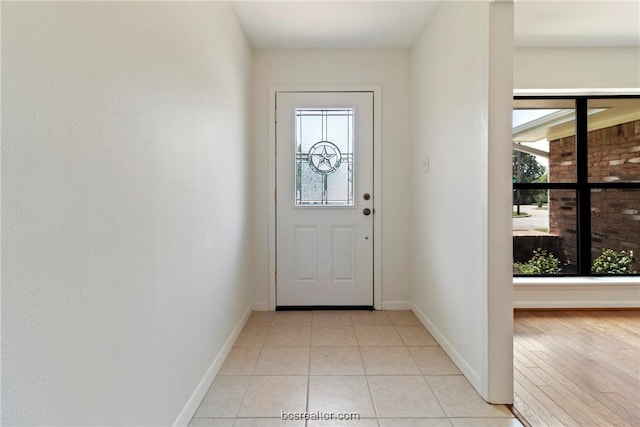 doorway to outside featuring a wealth of natural light and light hardwood / wood-style floors