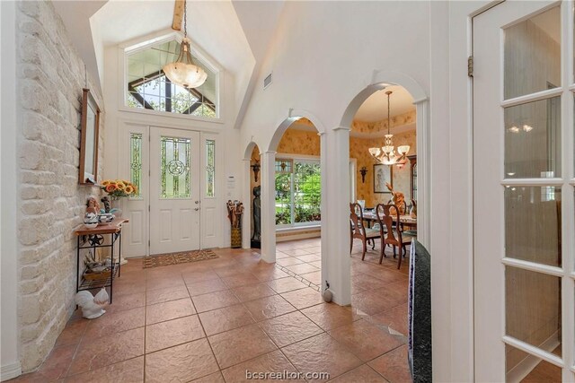 foyer entrance with an inviting chandelier and a towering ceiling