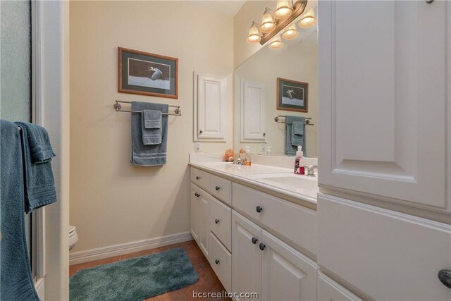 bathroom featuring tile patterned flooring, vanity, and toilet