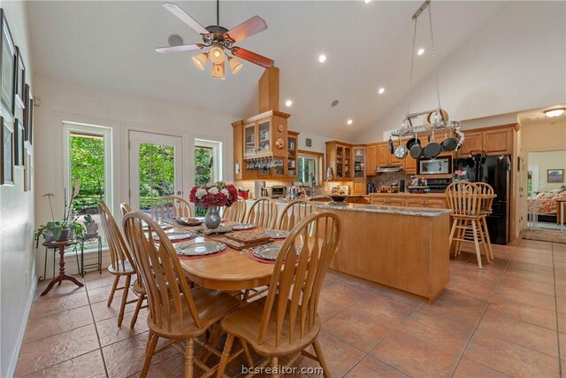 tiled dining space featuring high vaulted ceiling and ceiling fan