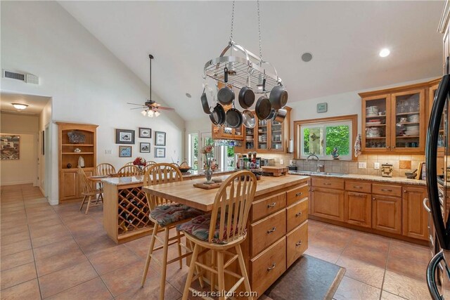 kitchen with a kitchen island, sink, a wealth of natural light, and backsplash