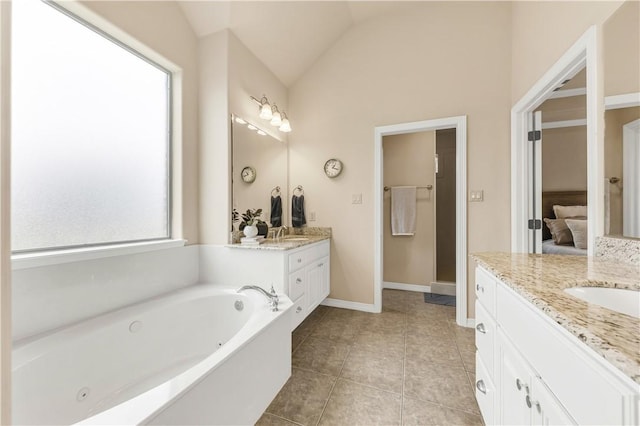 bathroom with tile patterned floors, lofted ceiling, vanity, and a washtub