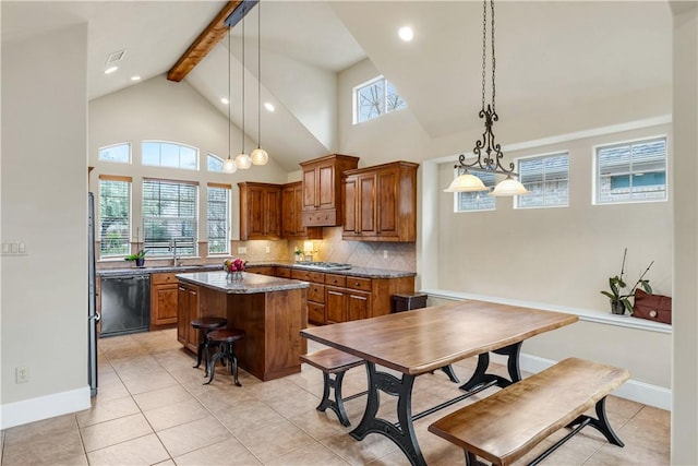 kitchen featuring decorative light fixtures, dishwasher, a kitchen island, stainless steel gas stovetop, and backsplash