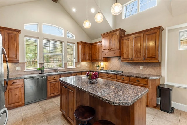 kitchen with pendant lighting, sink, a breakfast bar area, stainless steel appliances, and a kitchen island