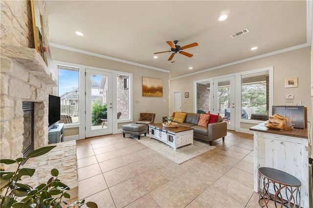 tiled living room with crown molding, french doors, and ceiling fan