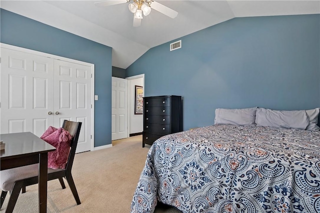 bedroom with light carpet, a closet, vaulted ceiling, and ceiling fan