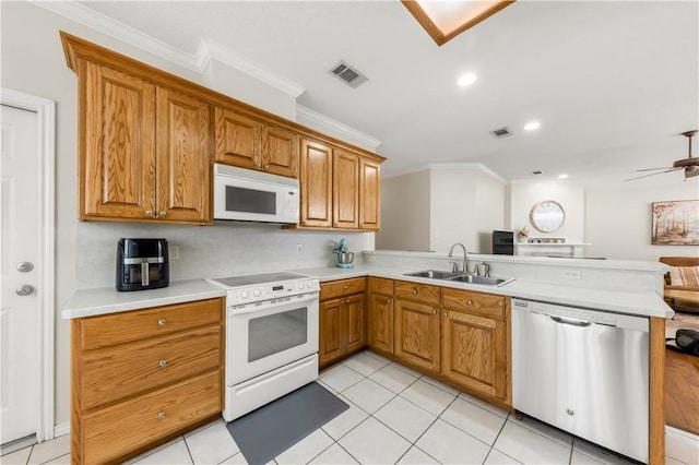 4414 Pickering Pl, College Station, TX 77845 - kitchen with white appliances, a sink, crown molding, a peninsula, and light countertops