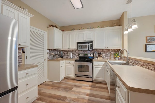 1610 Ethic Ln, College Station, TX 77845 - kitchen featuring stainless steel appliances, a sink, backsplash, a peninsula, and light wood finished floors