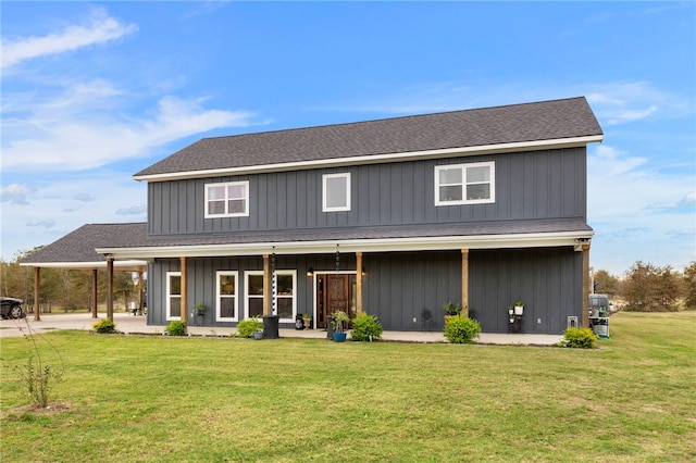 view of front of home with roof with shingles, a front lawn, and board and batten siding