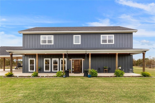 back of house featuring a shingled roof, a patio, board and batten siding, and a yard