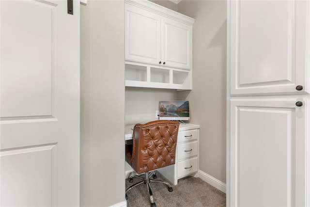 office area with a barn door, carpet, and baseboards