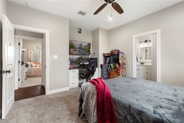 carpeted bedroom with a ceiling fan, visible vents, baseboards, and ensuite bathroom