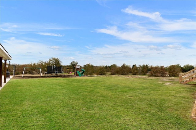 view of yard with playground community and a trampoline