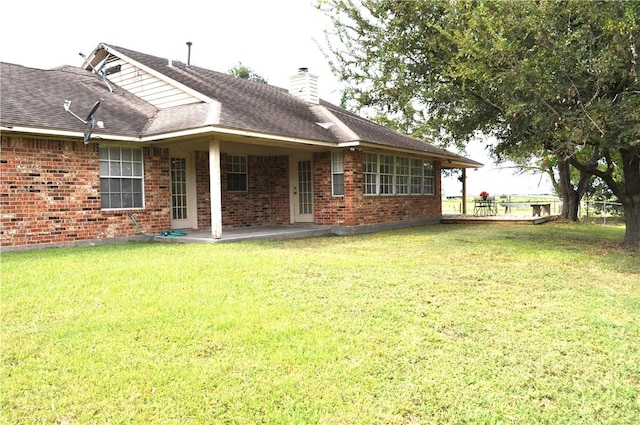 rear view of property with a yard and a patio area