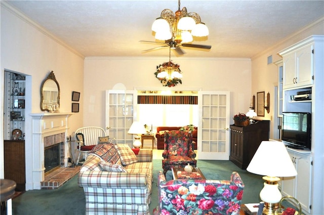 carpeted living room with ceiling fan with notable chandelier, a brick fireplace, and crown molding