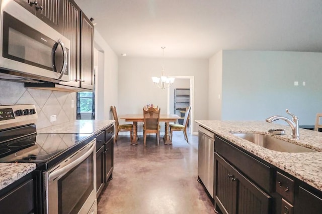 12029 Eagle Ln, North Zulch, TX 77872 - kitchen featuring appliances with stainless steel finishes, a chandelier, finished concrete floors, decorative backsplash, and decorative light fixtures