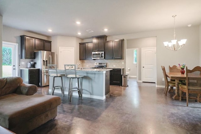12029 Eagle Ln, North Zulch, TX 77872 - kitchen with appliances with stainless steel finishes, backsplash, a chandelier, concrete flooring, and dark brown cabinetry