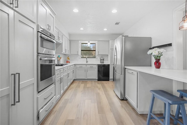 8700 Bent Tree Dr, College Station, TX 77845 - kitchen featuring stainless steel appliances, light wood-style floors, recessed lighting, a sink, and light countertops