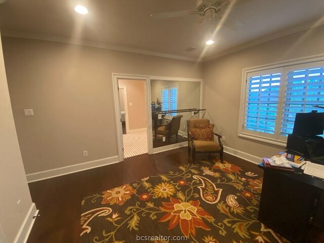 sitting room with ornamental molding, ceiling fan, and dark wood-type flooring