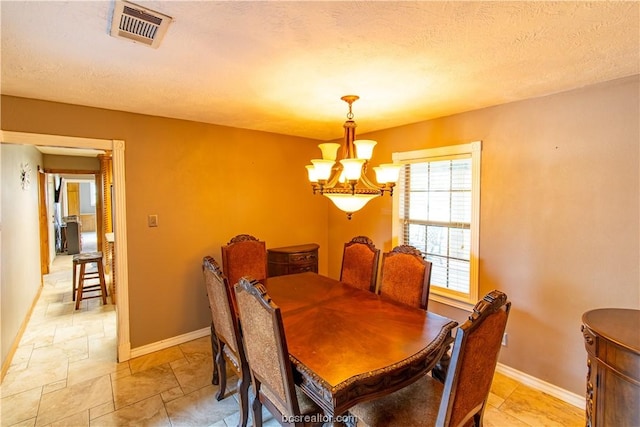 dining room featuring a textured ceiling and an inviting chandelier