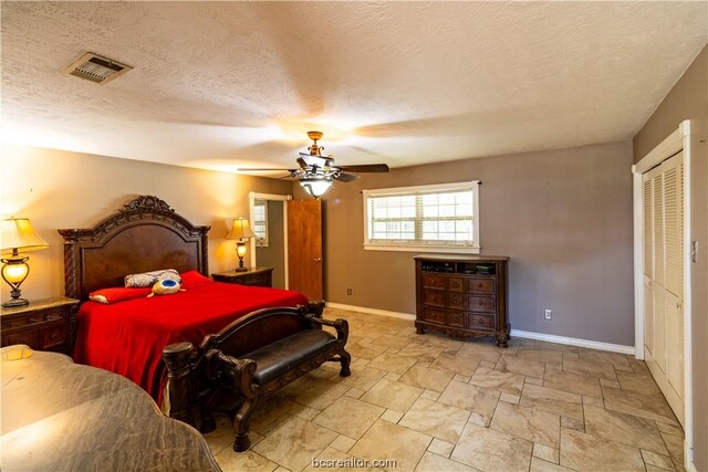 bedroom with ceiling fan, a textured ceiling, and a closet