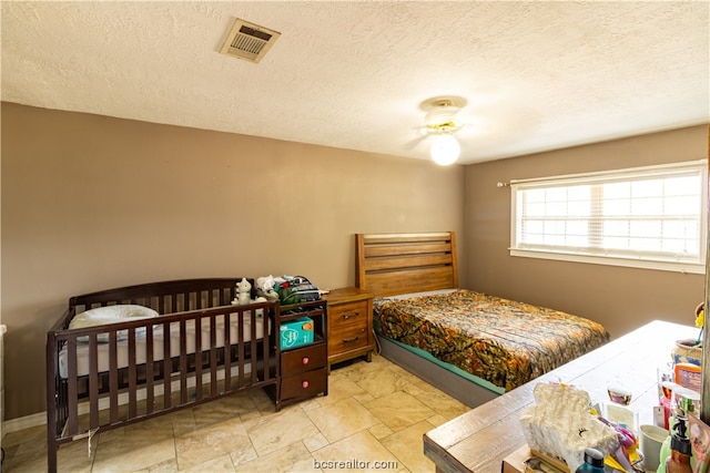 bedroom featuring ceiling fan and a textured ceiling