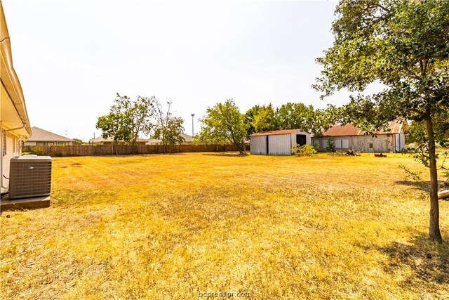 view of yard featuring central AC unit and a storage shed