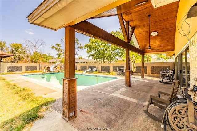 view of swimming pool with a water slide and a patio