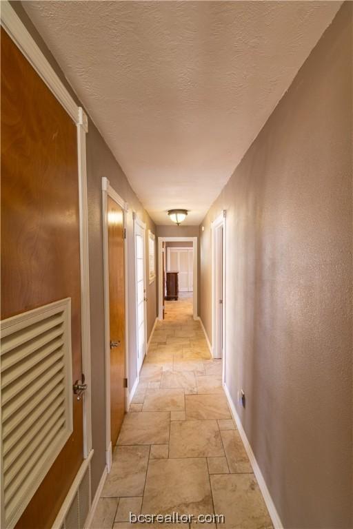 hallway with a textured ceiling