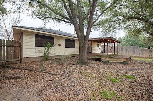 rear view of property with fence and a wooden deck