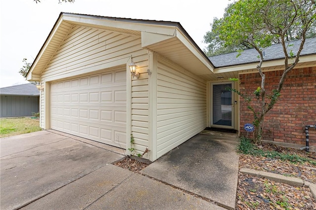 entrance to property with an attached garage, roof with shingles, and brick siding