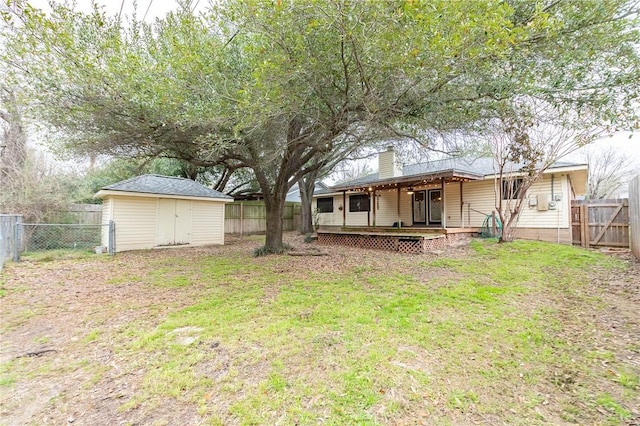 view of yard with a fenced backyard, an outdoor structure, a wooden deck, and a shed