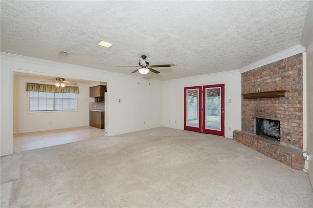 unfurnished living room featuring light carpet, a fireplace, visible vents, and crown molding