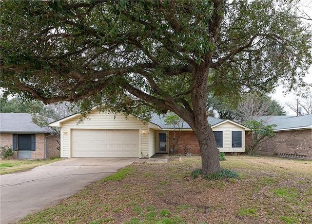 single story home featuring concrete driveway, brick siding, and an attached garage