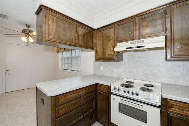 kitchen with a peninsula, under cabinet range hood, light countertops, and white range with electric cooktop