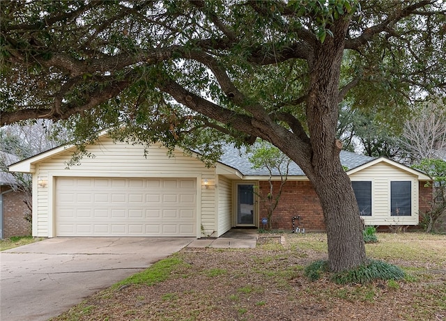 ranch-style house with a garage, driveway, brick siding, and a shingled roof