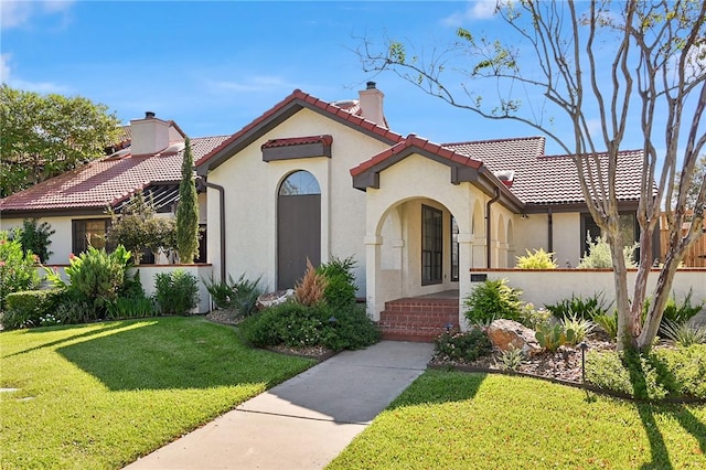 mediterranean / spanish home featuring a front lawn