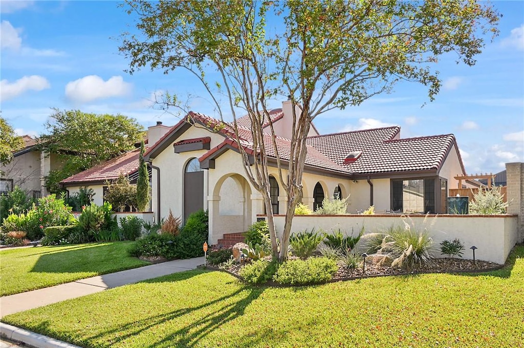 mediterranean / spanish home with a front yard